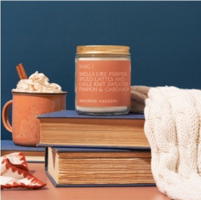 Candle styled with cocoa and knitwear